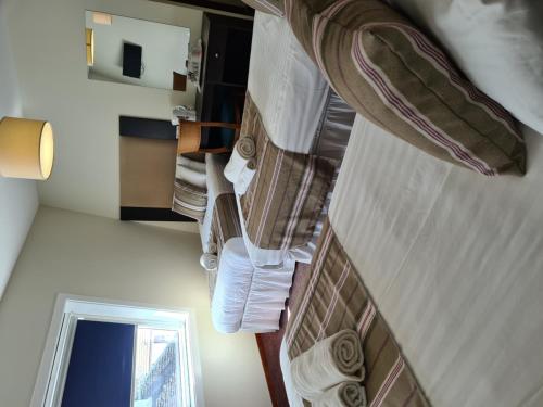 a room with a bed with towels and a mirror at Kings Arms Hotel - A Bespoke Hotel in Kyleakin