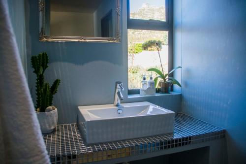a bathroom with a white sink and a window at Best Place Ever in Hout Bay