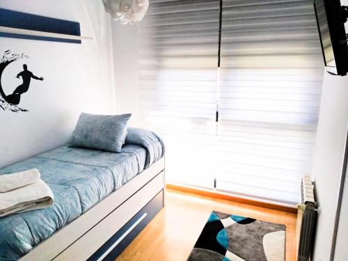 un dormitorio con una cama y una ventana en APARTAMENTO KENITRA, en Avilés