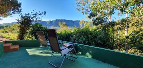 2 Stühle auf einer Veranda mit Bergblick in der Unterkunft CASA ACALANTA-Trilha das Flores-SERRA DA CANASTRA in São José do Barreiro
