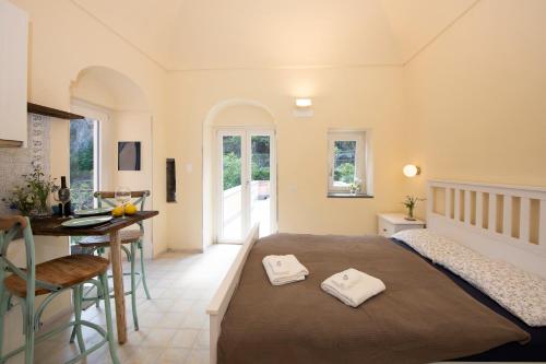 Un dormitorio con una cama y una mesa y una cocina. en Casa Claudia, en Ravello