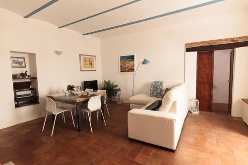 sala de estar con mesa y sofá blanco en Appartamento Palma Gold, en Spello