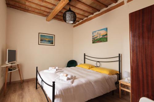 1 dormitorio con 1 cama grande con almohadas amarillas en Appartamento Palma Gold, en Spello