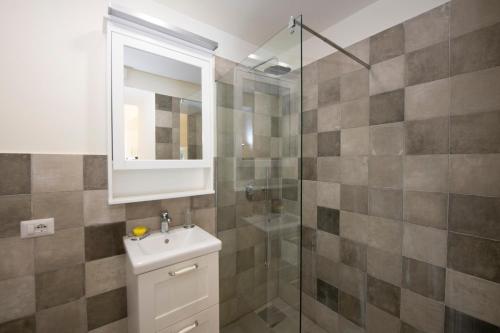 Un baño con lavabo y ducha de cristal. en Casa Claudia, en Ravello
