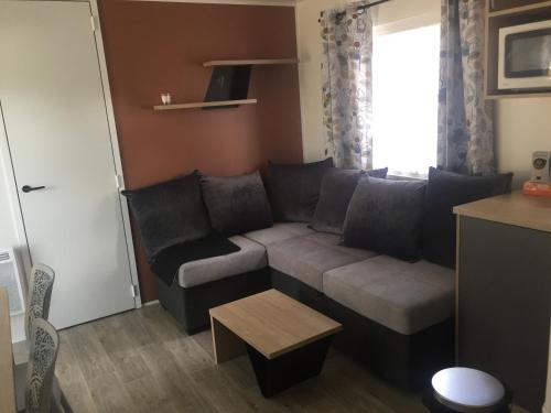 a living room with a couch and a table at LE PIPA in Quend
