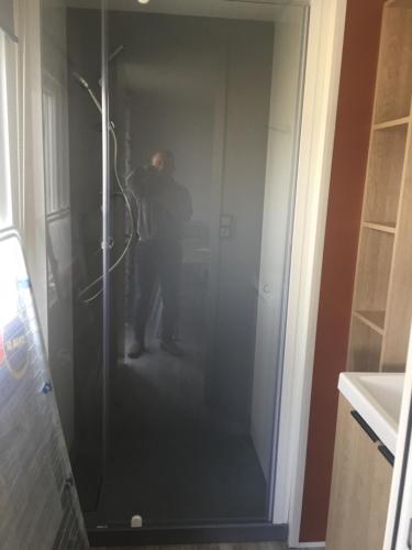 a man is standing in a bathroom with a hose at LE PIPA in Quend