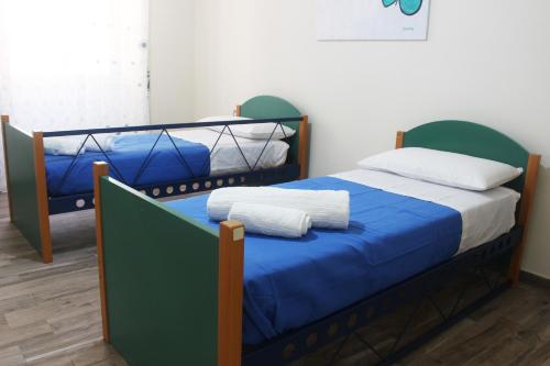a bedroom with two bunk beds with blue sheets at Casa Colapesce in Messina