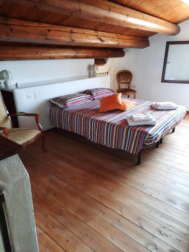 a bed in a room with a wooden floor at Casale Oasi in Pozzallo