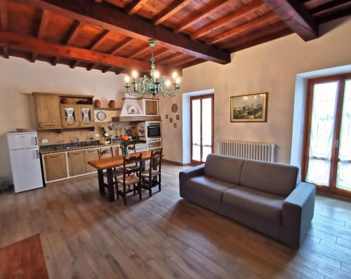 a living room with a couch and a table with chairs at Casa Remo - dolce soggiorno nella Piazza di Greve in Greve in Chianti