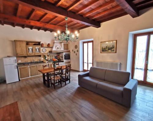 - un salon avec un canapé et une table avec des chaises dans l'établissement Casa Remo - dolce soggiorno nella Piazza di Greve, à Greve in Chianti