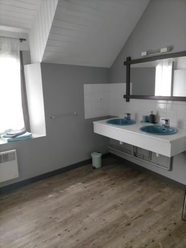 une salle de bain avec deux lavabos et deux fenêtres dans l'établissement Le gîte des Serres, à Parné-sur-Roc