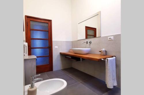 W łazience znajduje się biała umywalka i lustro. w obiekcie Casa Alda - magica vista sulla Piazza di Greve w Greve in Chianti