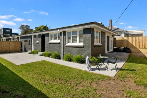 a house with a lawn in front of it at Bach on Pitau - Mt Maunganui Holiday Home in Mount Maunganui