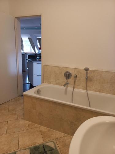 a bathroom with a bath tub and a sink at A-M Condominium in Veszprém