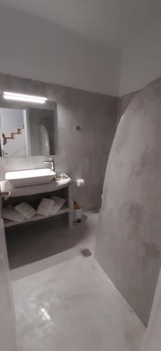 ein Bad mit einem Waschbecken und einem Spiegel in der Unterkunft Miramar Complex - Korfos in Korfos