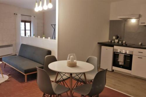 une cuisine et un salon avec une table et des chaises dans l'établissement Le Huitième - Avignon Intramuros, à Avignon