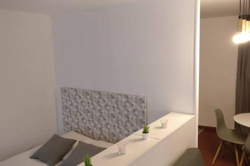 Cette chambre comprend un lit et une table avec un miroir. dans l'établissement Le Huitième - Avignon Intramuros, à Avignon