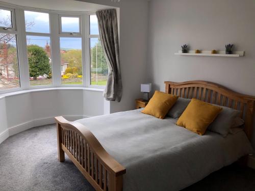 um quarto com uma cama com almofadas amarelas e uma janela em Acacia Breezes - Delightful Scarborough Semi em Scarborough