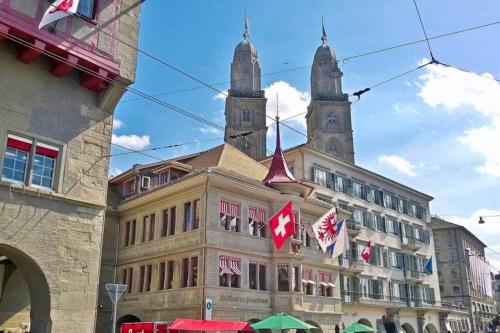 a large building with two towers with flags on it at Turicum Apartment mit Balkon und Parkplatz in Zürich