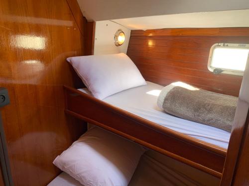 a small cabin with a bed and a window at NUIT SUR UN BATEAU in La Rochelle
