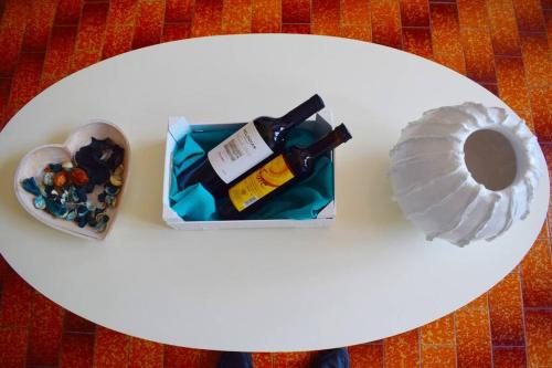 a white table with a bottle of wine and a shell at Magnificent sea view,clean and bright apartments in Kalathas
