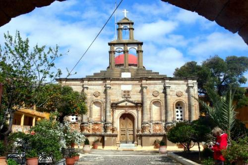 an old church with a clock tower on top of it at Magnificent sea view,clean and bright apartments in Kalathas