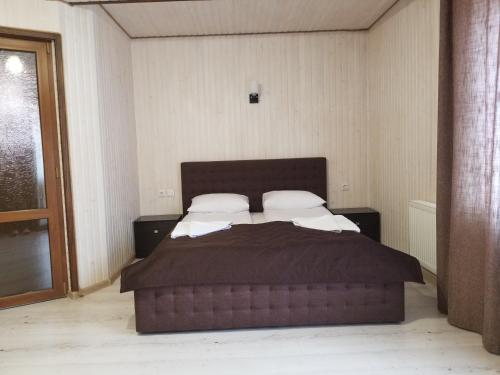 a bedroom with a large bed with two pillows at Guest House Mountain in Bukovel