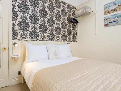 Schlafzimmer mit einem Bett mit einer schwarz-weißen Tapete in der Unterkunft 3 Dartview in Dartmouth