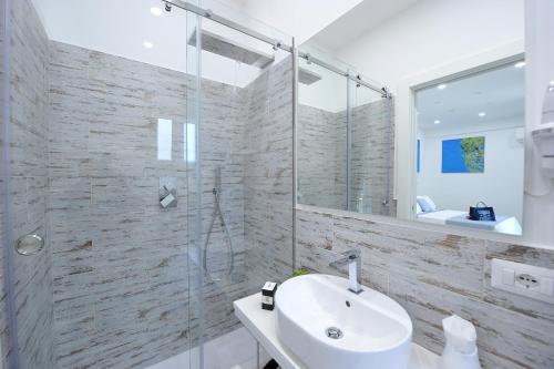 a bathroom with a sink and a glass shower at La Casa Degli Amici in Sorrento