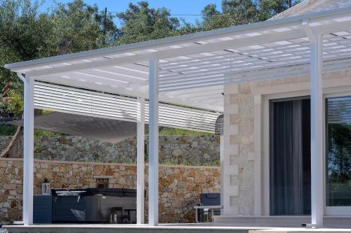 a white pergola on top of a house at Paxos Luxury Living Junior Suites in Gaios