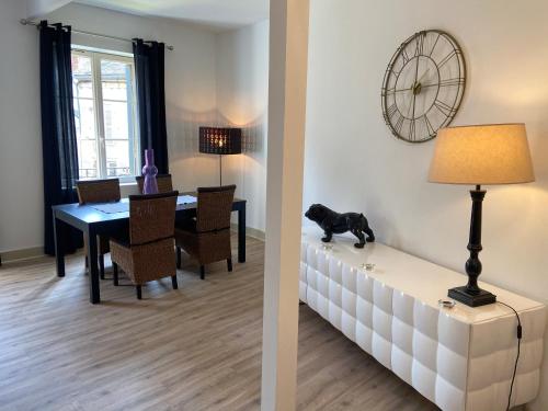 - un salon et une salle à manger avec un chien assis sur un canapé dans l'établissement Le cosy, à Sarlat-la-Canéda