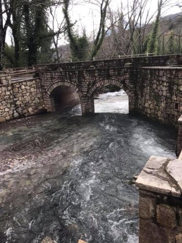 a stone bridge over a river with water underneath at Hotel Isaraiko Spiti Agia Theodora in Isaris