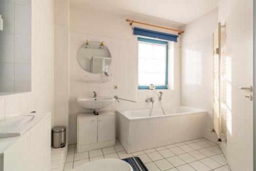 ein weißes Badezimmer mit einem Waschbecken, einer Badewanne und einem WC in der Unterkunft Ferienwohnung #1 Am Neuensiener See - Seedorf in Sellin