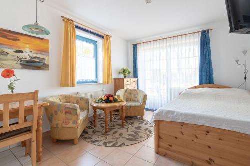 Schlafzimmer mit einem Bett, einem Tisch und Stühlen in der Unterkunft Ferienwohnung #1 Am Neuensiener See - Seedorf in Sellin