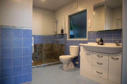 a bathroom with a toilet and a sink and a shower at Soul Retreat - Cable Bay Holiday Home in Cable Bay