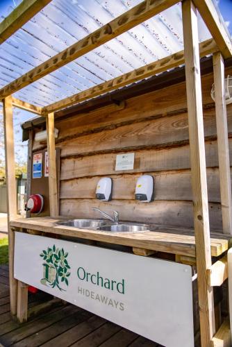 a outdoor kitchen with a sink in a wooden building at Orchard Hideaways in Penrith