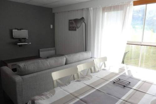 un salon avec un canapé et une table dans l'établissement Appartement au pied des pistes 49m2 -4-5 pers, à Prémanon
