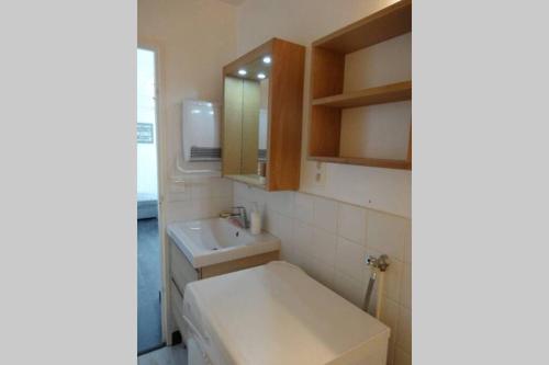 une salle de bain blanche avec un lavabo et un miroir dans l'établissement Appartement au pied des pistes 49m2 -4-5 pers, à Prémanon