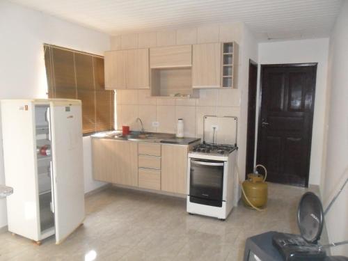 a kitchen with a white refrigerator and a stove at ASSEL LOFT XAXIM in Curitiba