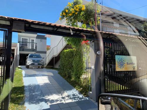 a building with a gate with flowers on it at Stada San Jose Airport Hotel in Alajuela City