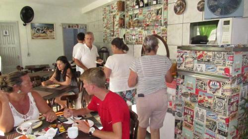 a group of people standing in a kitchen at Hotel Pousada Girassol in Matinhos