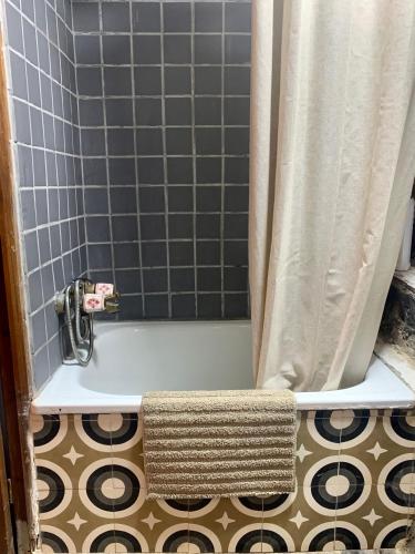 a bathroom with a bath tub with a shower curtain at La Cabaña del Beyu Pen in Amieva