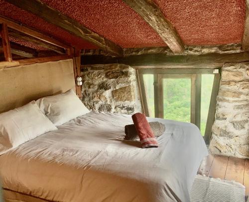 - une chambre avec un lit dans une pièce dotée d'une fenêtre dans l'établissement La Cabaña del Beyu Pen, à Amieva