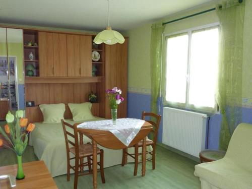 un salon avec une table et un lit dans l'établissement Chambres d'Hôtes de l'Auraine, à Limoges