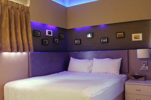 a bedroom with a large bed with purple lighting at Lazy House in Hengchun South Gate