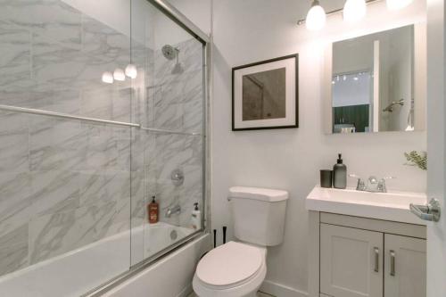 a bathroom with a shower and a toilet and a sink at West Loop 1BR Apartment with In-Unit Laundry - Lake 301 in Chicago