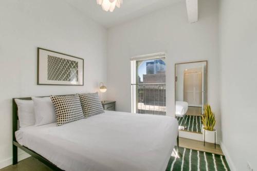 a white bed in a room with a window at West Loop 1BR Apartment with In-Unit Laundry - Lake 301 rep in Chicago