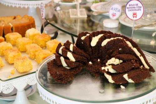 a chocolate cake on a plate on a table with other desserts at Hotel Britannia in Penedo