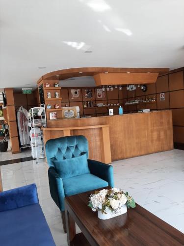 ein Zimmer mit einem blauen Stuhl und einem Tisch in der Unterkunft سمأ الرفاع للشقق المخدومة in Khobar