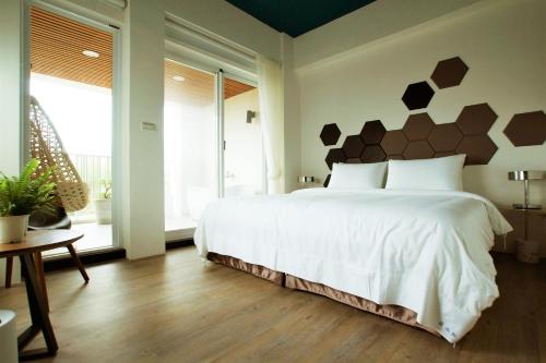 a bedroom with a white bed with a geometric headboard at 墾丁後灣 藍水軒海景民宿 in Checheng
